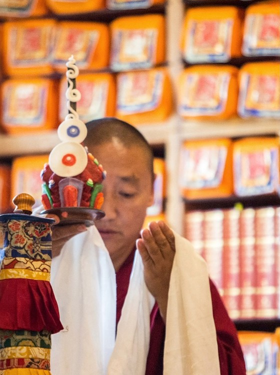 Buddhist meditation and dharma teacher and Tibetan Buddhist monk Lama Oser performing rituals in mediation hall.