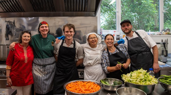 Smiling group of kitchen volunteers at Buddhist Centre in Yorkshire UK.