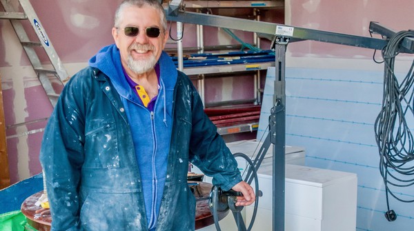 Man in blue clothes while decorating as a voluntary job at Buddhist Centre.
