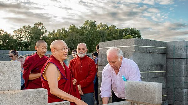 Buddhist monk and several men doing building works for Buddha Temple in Yorkshire, England, UK.